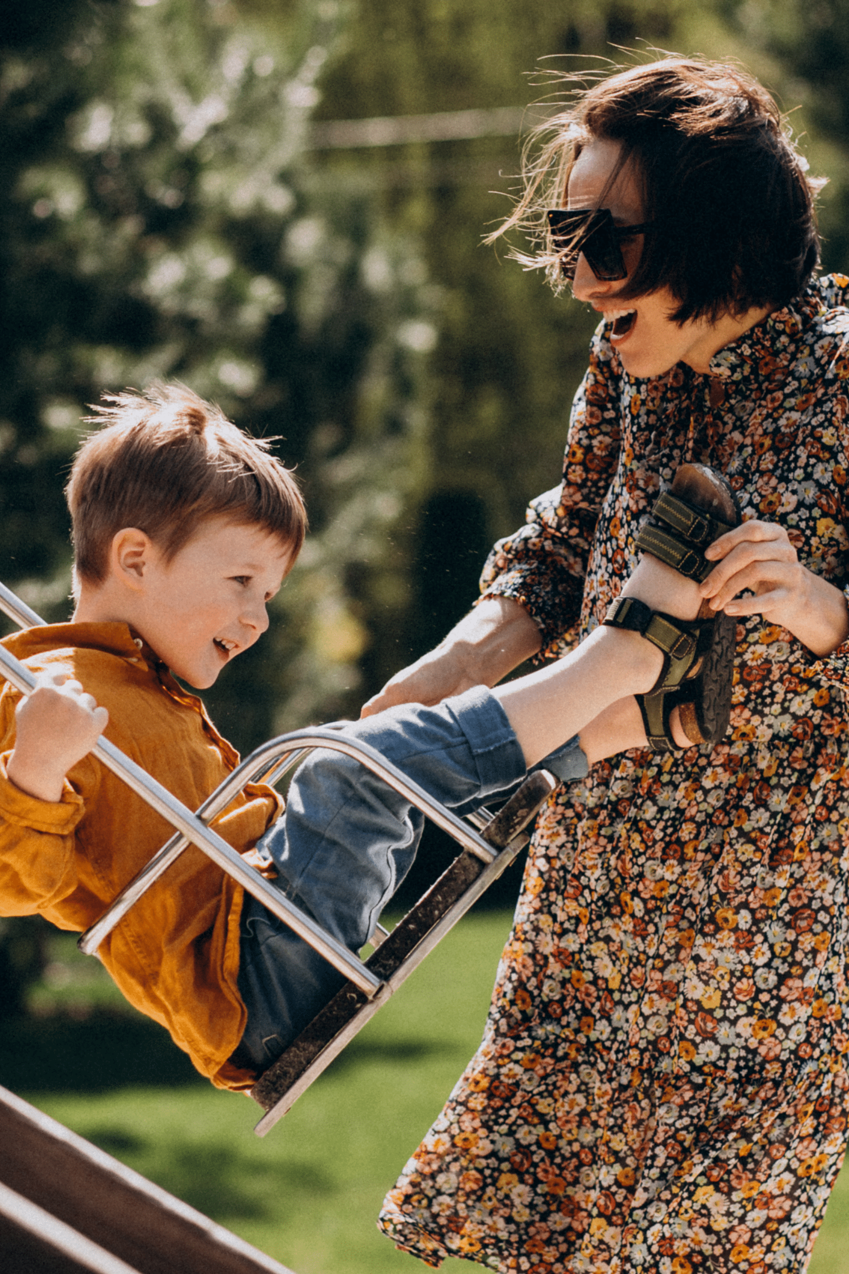 Mother pushing son on swing