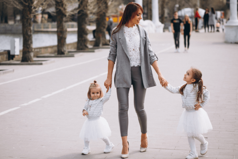 Mother walking holding two daughters hands