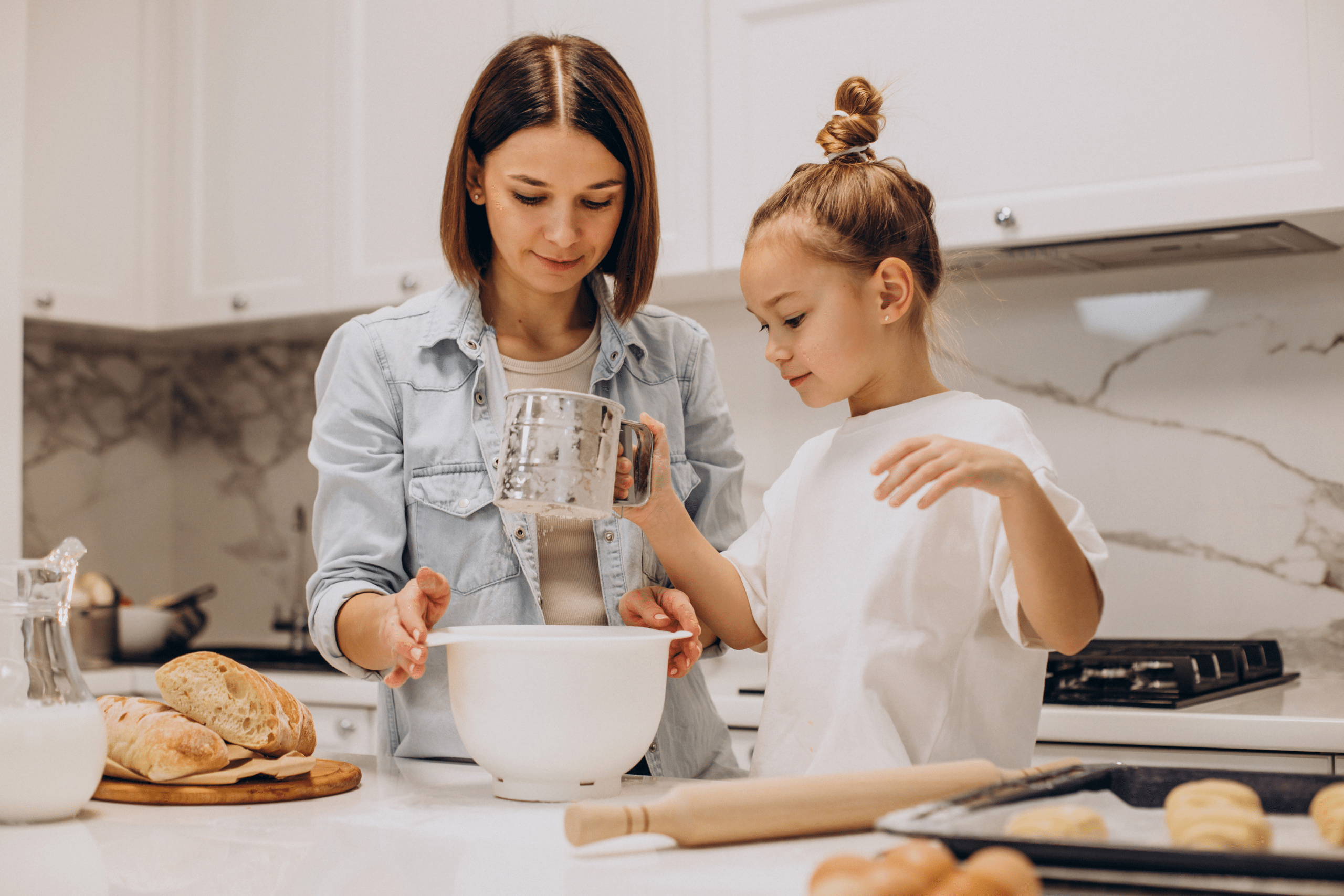 Nanny helping little girl bake